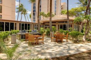 un patio con mesas y sillas frente a un edificio en Mahana at Kaanapali 511, en Honokowai