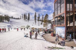 a group of people on a ski slope next to a building at The Summit 67 in Old Mammoth