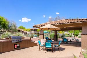 - une terrasse avec un barbecue, des chaises et un parasol dans l'établissement Vistoso Resort Casita #149, à Tortolita