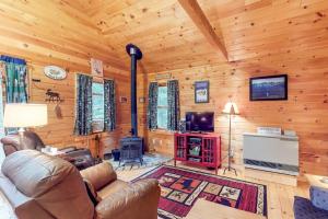 uma sala de estar com um sofá e uma televisão numa cabina em Maine Attraction em Upper Shirley Corner