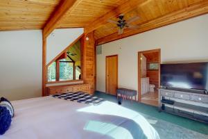 a bedroom with a large bed and a flat screen tv at Gordon Haus at Kahler Glen in Lake Wenatchee