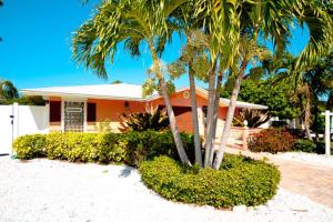 a house with two palm trees in front of it at Tropical Oasis in Anna Maria