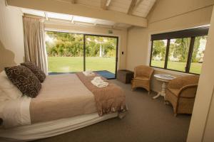 een slaapkamer met een groot bed en een groot raam bij Rathmoy Lodge in Hunterville