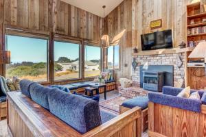 sala de estar con chimenea y TV en Clemons' Cottage, en Sea Ranch