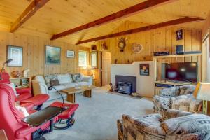 sala de estar con sofás, TV y chimenea en The Cabin At Penn Cove, en Coveland