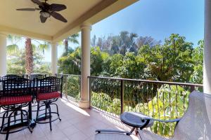 a porch with chairs and tables and a balcony with trees at La Casa Karen in Anna Maria
