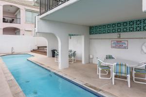 uma piscina com mesa e cadeiras ao lado de um edifício em Florence #707 em South Padre Island