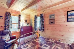 uma cabina de madeira com uma cama e um sofá em Maine Attraction em Upper Shirley Corner