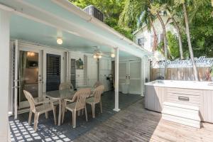 una casa con patio con mesa y sillas en Amelia House en Key West