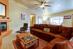 a living room with a brown couch and a fireplace at Cottonwoods 455 in Moab