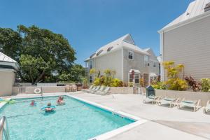 una familia nadando en una piscina en una casa en Casa Bonita @ Duval Square R1, en Key West