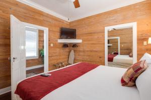 a bedroom with a bed and a tv on the wall at Leeward Isle in Key West