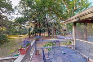 a porch with a table and a fence with trees at Oceanwoods 443 in Kiawah Island