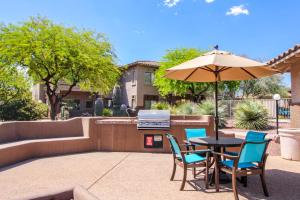 eine Terrasse mit Tisch und Stühlen und einem Sonnenschirm in der Unterkunft Vistoso Resort Casita #126 in Tortolita