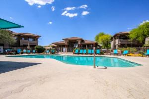 una piscina en un complejo con sillas azules en Vistoso Resort Casitas #101, en Tortolita