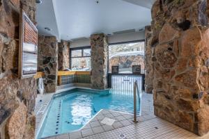 a pool in a room with a stone wall at Shoshone 1954 in Big Sky