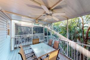a porch with a table and chairs and a ceiling fan at North Beach Village 27 in Holmes Beach