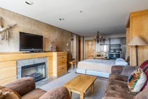 uma sala de estar com uma cama e uma lareira em Shoshone 1960 em Big Sky