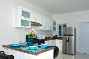 a kitchen with a counter with blue plates and a refrigerator at Rosil Place in San Felipe de Puerto Plata