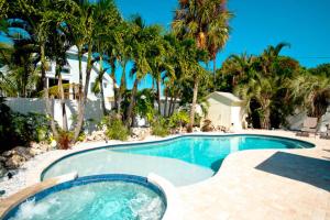 a swimming pool with palm trees in front of a house at Tropical Oasis in Anna Maria