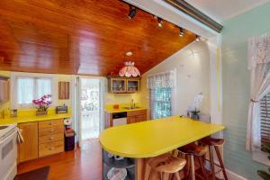 a kitchen with a yellow counter top and wooden floors at Gingerbread in Key West
