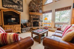 a living room with two couches and a fireplace at Lake 5 Cabin in West Glacier