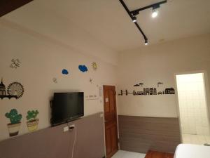 a living room with a flat screen tv on a wall at Fu Xing Homestay in Magong