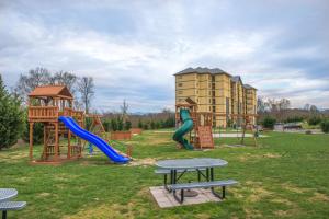 een park met een speeltuin met twee glijbanen en een tafel bij Sandy's Sanctuary in Pigeon Forge