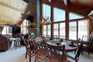 a dining room with a table and chairs and windows at Lodge at Moosehead Lake in Greenville Junction