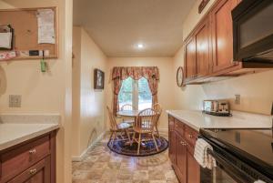 una cocina con armarios de madera, mesa y sillas en 38 Kandahar Lane, en Conway