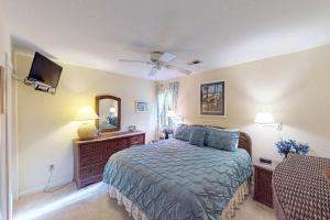 a bedroom with a bed and a television in it at Oceanwoods 443 in Kiawah Island