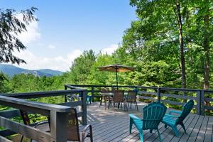 eine Terrasse mit Stühlen und einem Tisch mit einem Sonnenschirm in der Unterkunft New England Treasure in North Conway