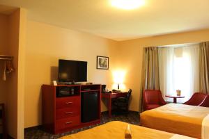 a hotel room with two beds and a television at Quality Inn Southampton in Southampton
