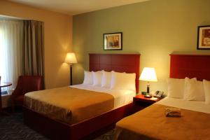 a hotel room with two beds and a chair at Quality Inn Southampton in Southampton +33 photos
