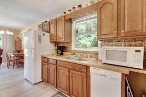 cocina con armarios de madera y nevera blanca en 2 Bed 1 Bath Vacation home in Sylva, en Sylva