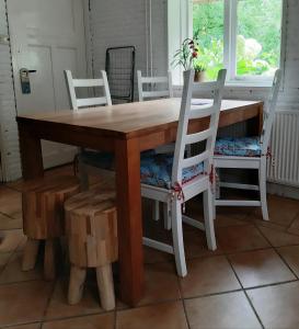 einen Holztisch mit zwei weißen Stühlen um ihn herum in der Unterkunft Riley's cottage in Hemrik