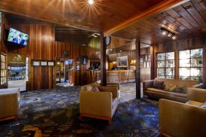 a lobby of a hotel with couches and a television at O'Reilly's Rainforest Retreat in Canungra