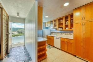 a kitchen with wooden cabinets and a large window at Harbor View Plaza #1203 in Honolulu