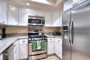 a kitchen with white cabinets and a stainless steel refrigerator at North Beach A in San Clemente