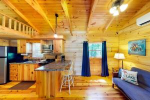 Cabaña de madera con cocina con encimera y sofá azul en Rocky Creek Cabin A, en Lake Murray Shores