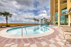 una piscina con sillas y un edificio en Phoenix West II #1916 en Orange Beach