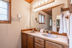 Un baño con dos lavabos y un espejo. en Hidden Village 724, en Big Sky 22 fotos más