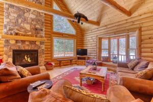 ein Wohnzimmer mit einem Steinkamin in einer Blockhütte in der Unterkunft Lazy Bear Lodge in Conway