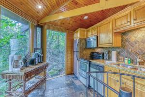 una cocina con armarios de madera y una gran ventana en Slopesider 27 en Sugar Mountain