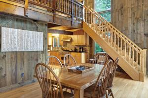 un comedor con una mesa de madera y una escalera en 468 Pequawket Drive, en Conway