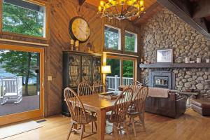 a dining room with a table and chairs and a fireplace at 468 Pequawket Drive in Conway