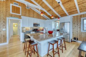 a kitchen with a large island with bar stools at 37 Ocean Bay Blvd in Ocean Bay Park