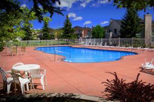 a swimming pool with chairs and a table and a table and chairs at Harbor Village 14-Plex Condo 120 in Garden City