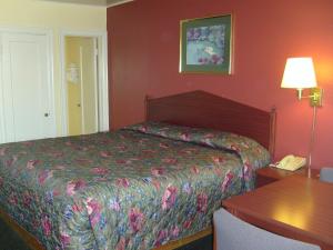 a bedroom with a bed and a table and a telephone at Cascade City Center Motel in Lebanon
