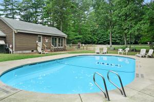 a swimming pool in a yard with a house at North Conway Townhouse 3H in North Conway